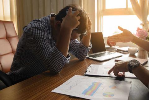 Stressed man looking at paperwork